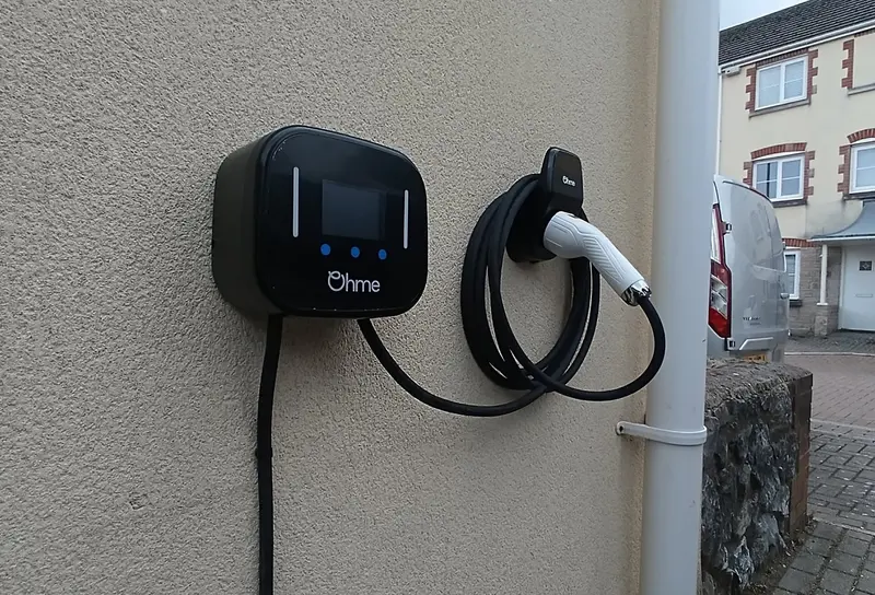 Professional Ohme EV home charger installation on a brick wall in Plymouth, featuring the Ohme home pro smart charger.