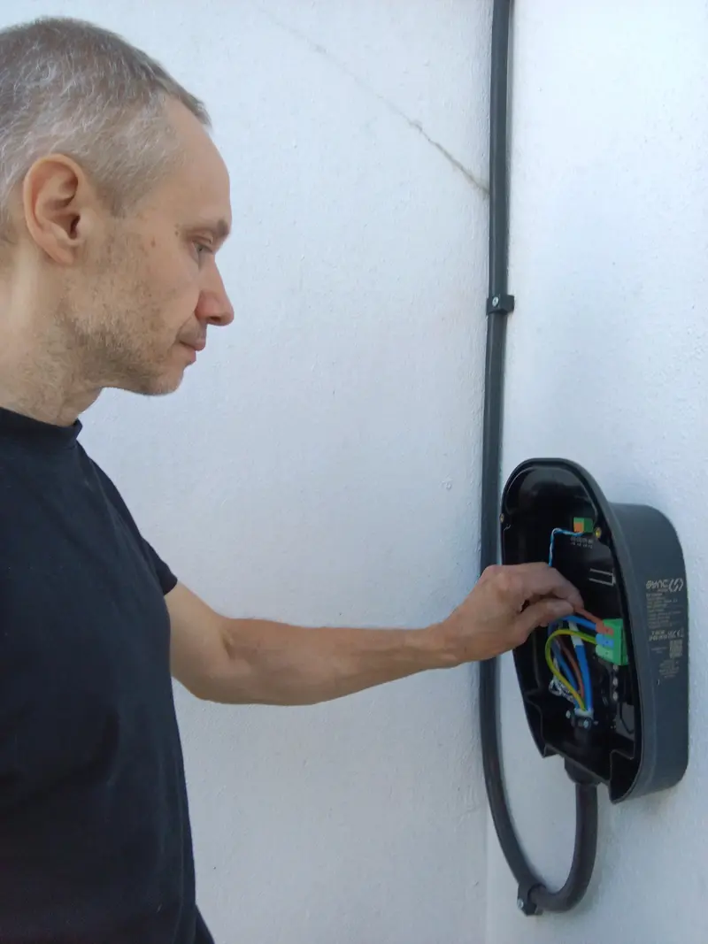 Qualified local electrician safely wiring a Sync EV home charging unit on a residential property in Plymouth